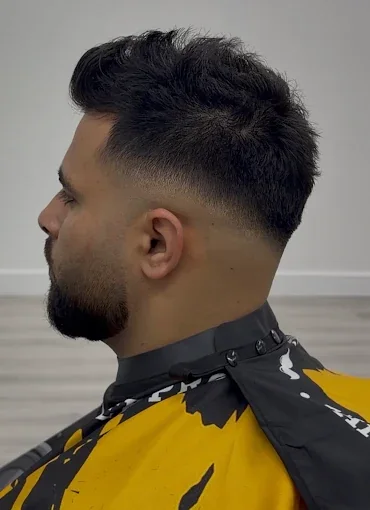 Customer profile showing a blended fade with a textured top and shaped beard